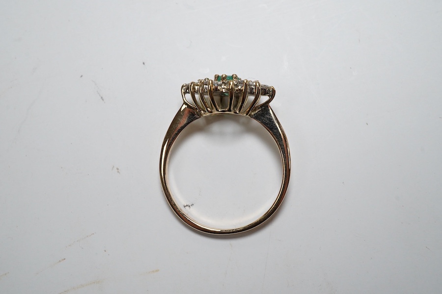 A yellow metal, emerald and diamond cluster set navette shaped ring, size P, gross weight 2.3 grams. Condition - fair to good